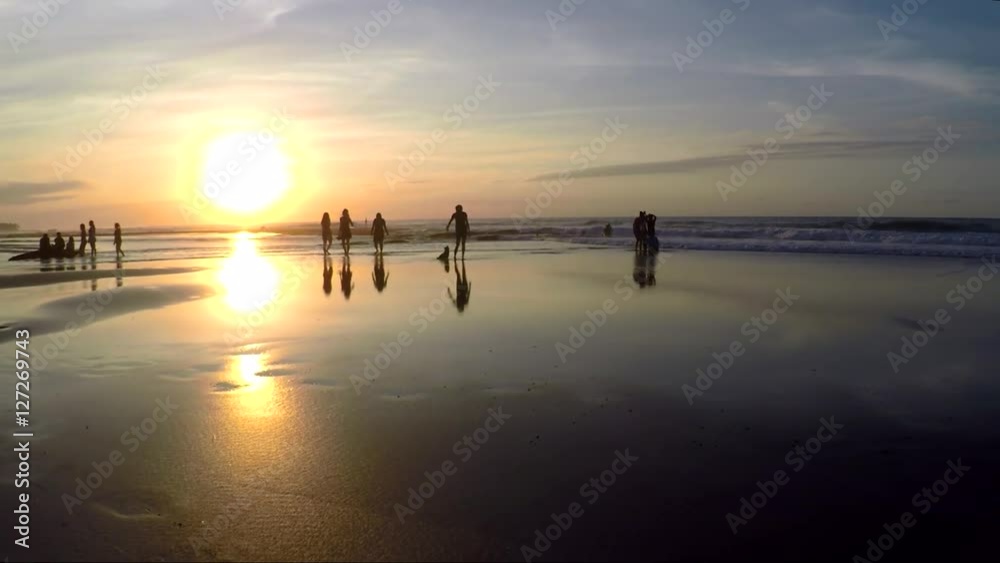 View of people relaxing on beach during sunset View of people relaxing on beach during sunset