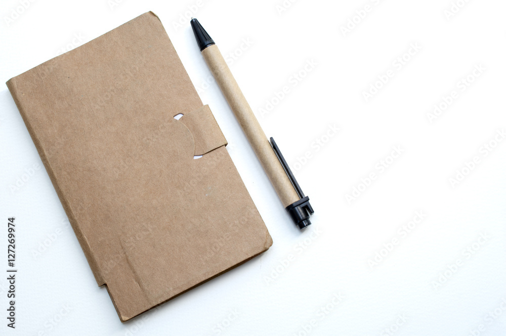 Notebook pen on the table cut white backdrop. Notebook pen on the table cut white backdrop.