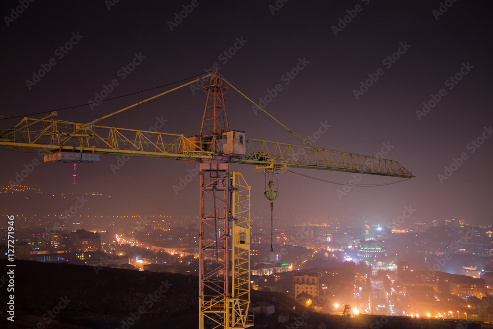 a night landscape hoisting crane and city