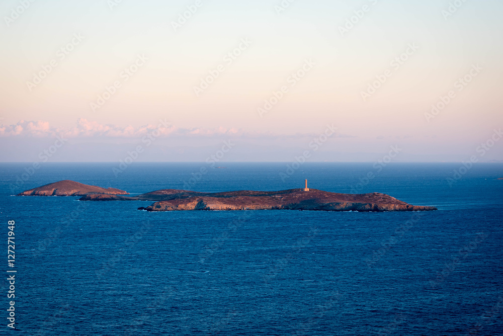 Island with isolated lighthouse at dusk