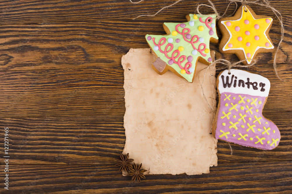 Christmas background with copy space. Gingerbread cookies hanging over wooden background. Christmas decorations top view with copy space. Prepare for xmas eve or other winter holidays Christmas background with copy space. Gingerbread cookies hanging over wooden background. Christmas decorations top view with copy space. Prepare for xmas eve or other winter holidays