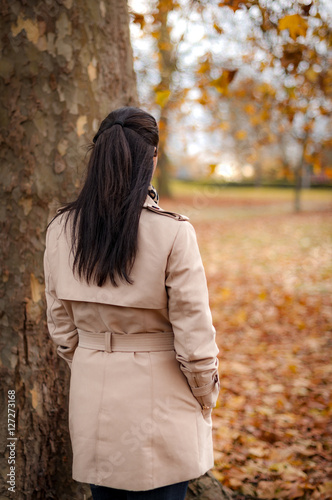 Fotografija Back of the head image of a mature woman wearing a trench coat in the park watch