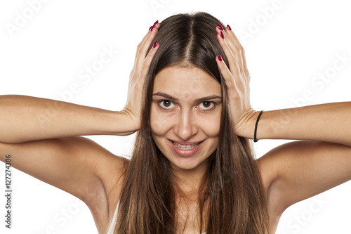 happy young woman is holding her hands to the head