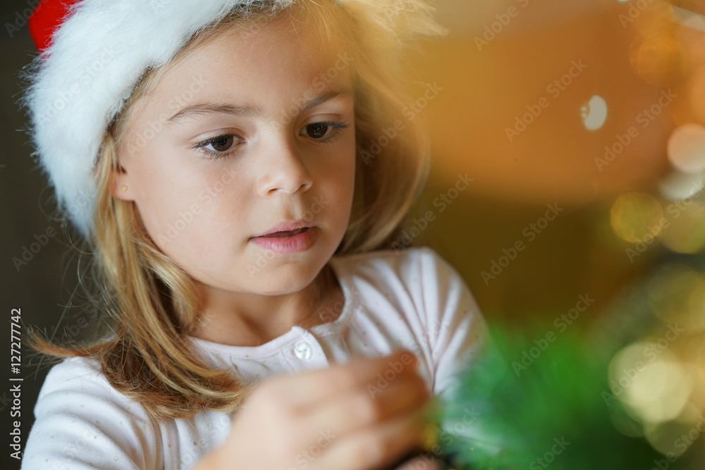 Portrait of cute little girl decorating Christmas tree Portrait of cute little girl decorating Christmas tree