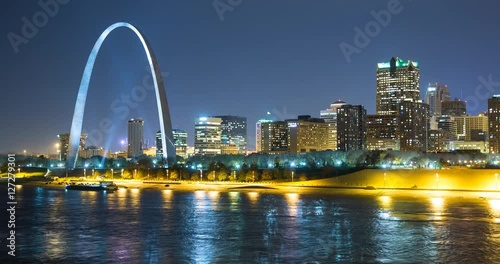 St. Louis, Missouri, USA - view of the illuminated city at night with the Gateway Arch monument and the Mississippi River - Timelapse with zoom out 