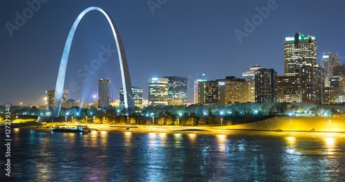 St. Louis, Missouri, USA - view of the illuminated city at night with the Gateway Arch monument and the Mississippi River - Timelapse with pan right to left