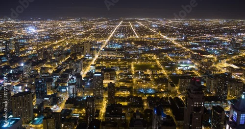 Chicago, Illinois, USA - view from the observatory of the John Hancock Center of illuminated City facing west at night - Timelapse with pan left to right 