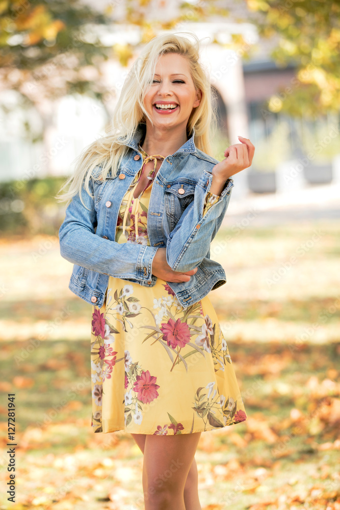 Frau im gelben Blumenkleid und Jeansjacke im Herbst Stock Photo | Adobe  Stock