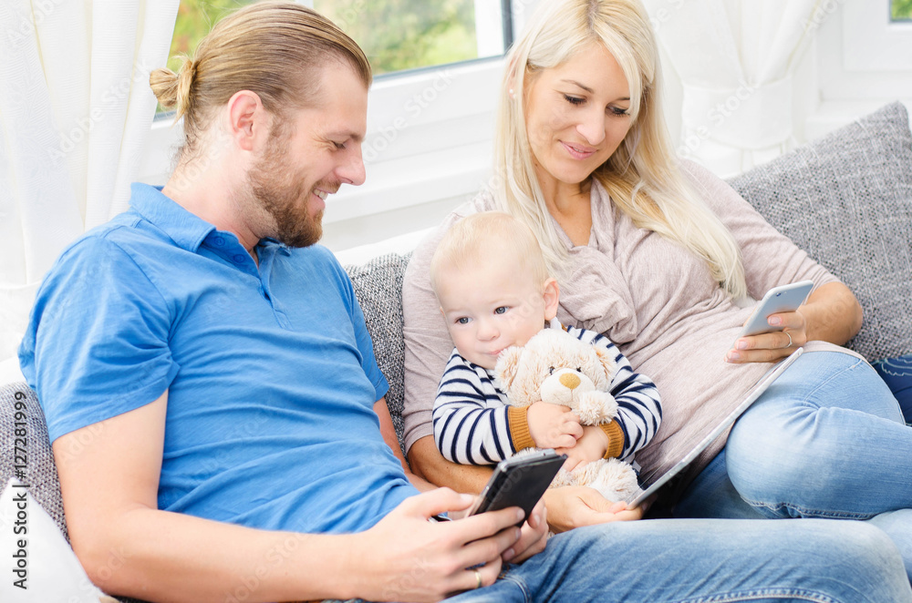 Junge Familie mit Tablett und Handy Junge Familie mit Tablett und Handy