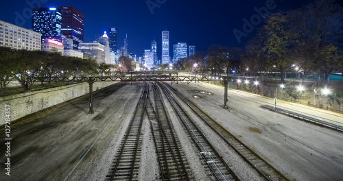 Chicago, Illinois, USA - rails and the Chicago L / Elevated near Millennium Park with illuminated Skyline in the background at night - Timelapse with zoom out 
