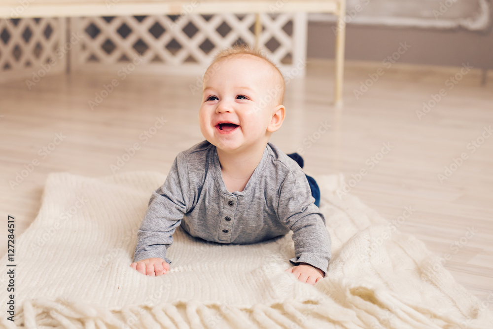 Adorable laughing baby boy in white sunny bedroom. Newborn child relaxing. Family morning at home. Adorable laughing baby boy in white sunny bedroom. Newborn child relaxing. Family morning at home.