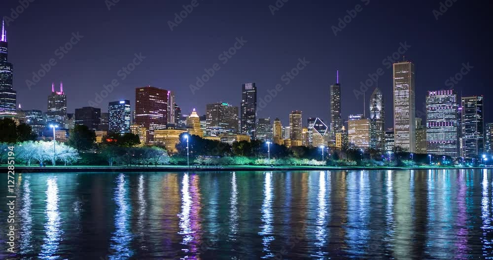 Chicago, Illinois, USA - view from the Lakefront Trail at the Field Museum / Shedd Aquarium facing north at shore of Lake Michigan and the skyline at night - Timelapse with zoom in 