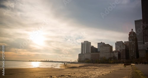 Chicago, Illinois, USA - view from the Oak Street Beach to John Hancock Center after sunrise with clouds and colorful sky at the shore of Lake Michigan - Timelapse with zoom out 