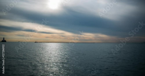Chicago, Illinois, USA - view from Navy Pier facing Lake Michigan with lighthouse and boats after sunrise - Timelapse with zoom out 