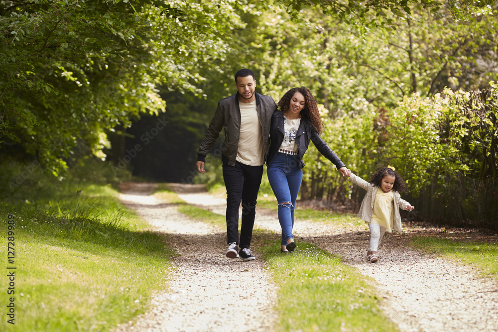 Couple with young daughter on a country walk, front view