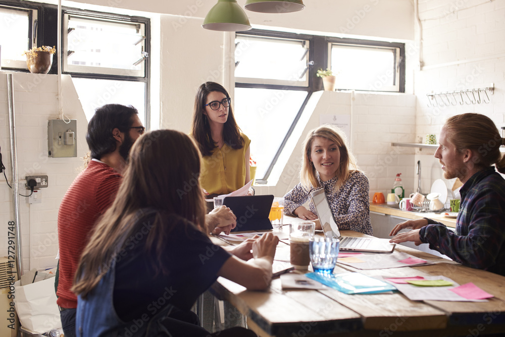 Female Manager Leads Meeting Around Table In Design Office