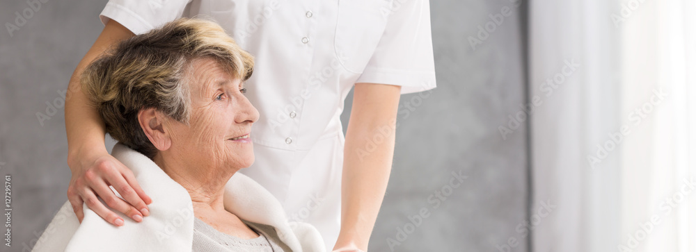 Fototapeta premium Nurse standing behind senior woman
