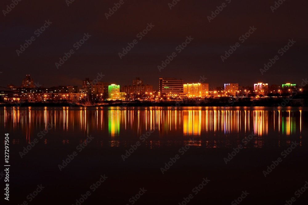 evening city landscape with reflection in the ice lake