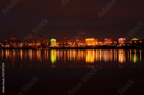 evening city landscape with reflection in the ice lake