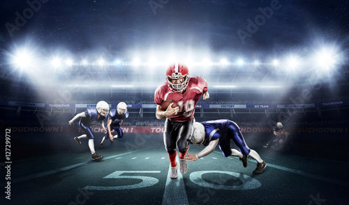 American football players in action on stadium with ball