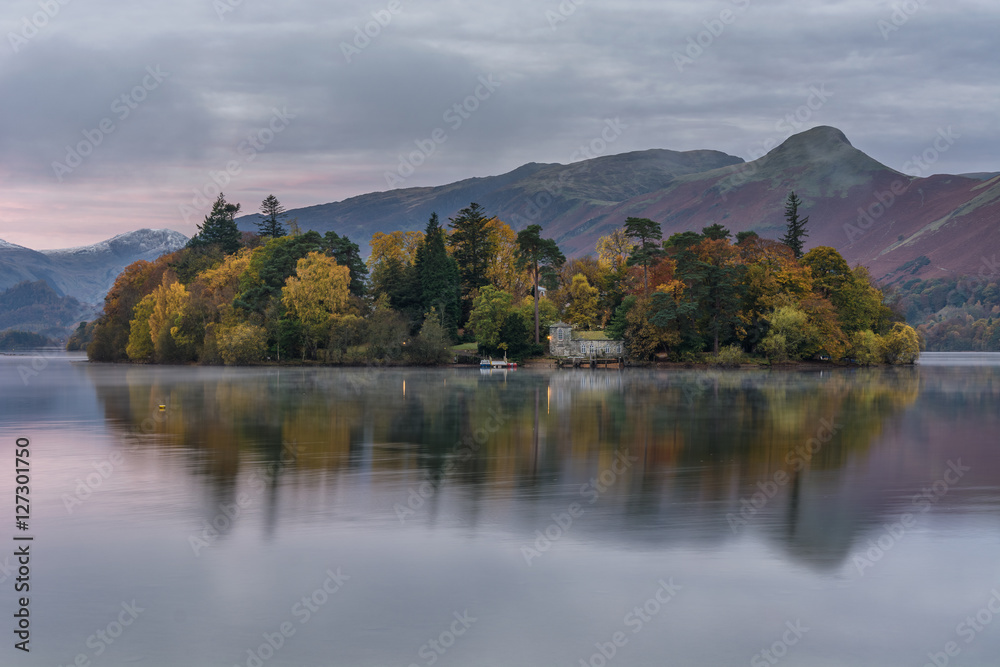 Autumn trees on a cloudy morning at Derwentwater in the Lake District.