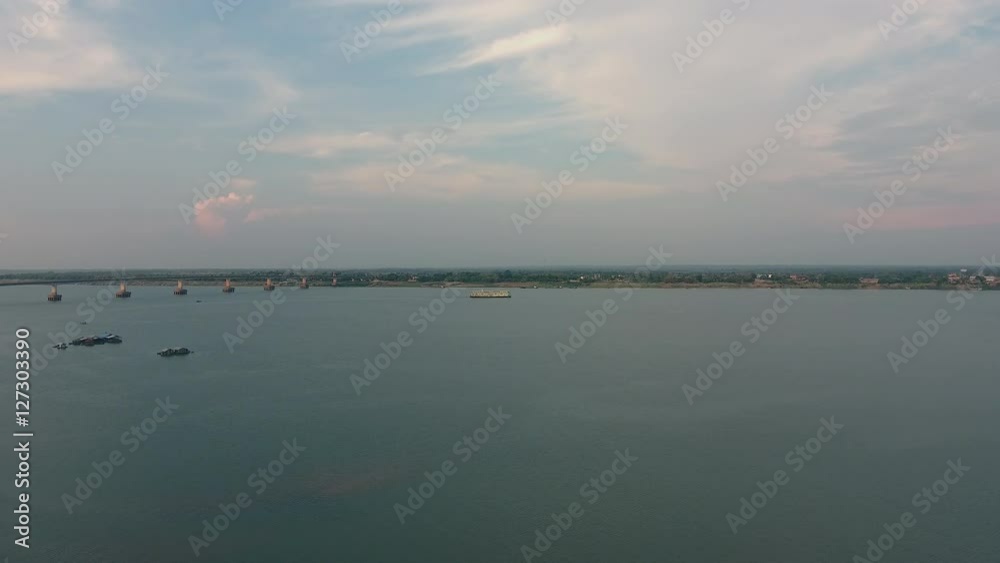 Drone shot: River cruise sailing on the mekong river under a cloudy sky