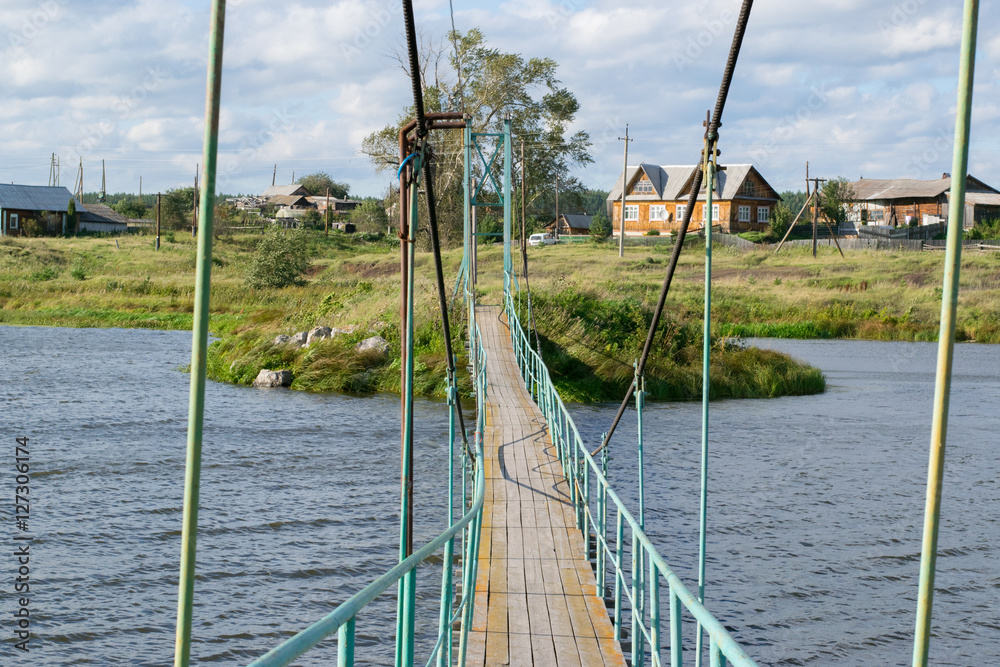 Russian rural landscape with a bridge over river