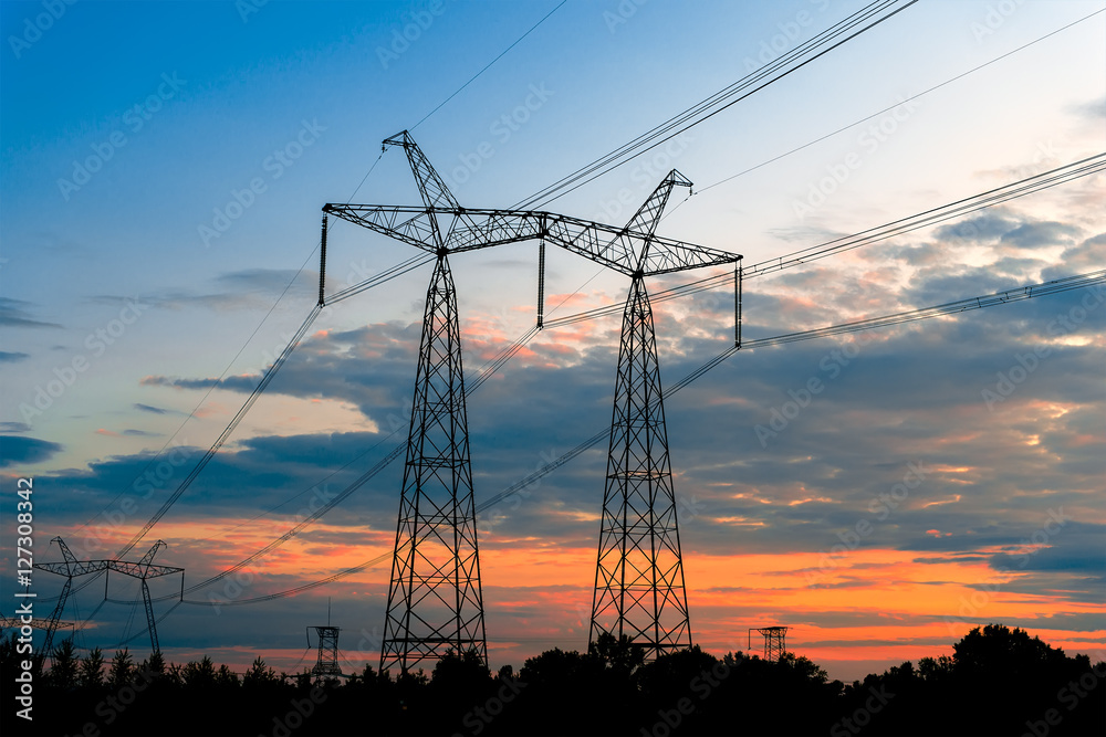 Electricity pylons at sunset with power horizon.