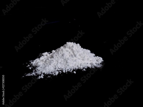 Cocaine drug powder pile on black background