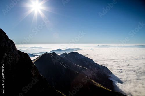 mystische Wolken und Nebelschleier zwischen Berggipfeln im Spätsommer in den Alpen photo