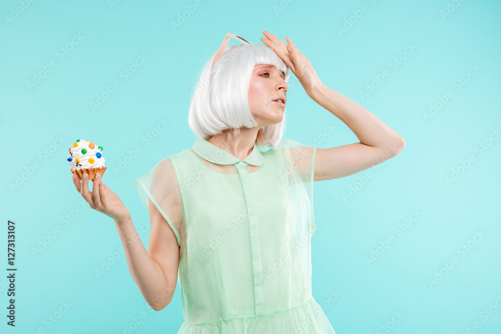 Sad upset blonde young woman refusing of sweet cupcake