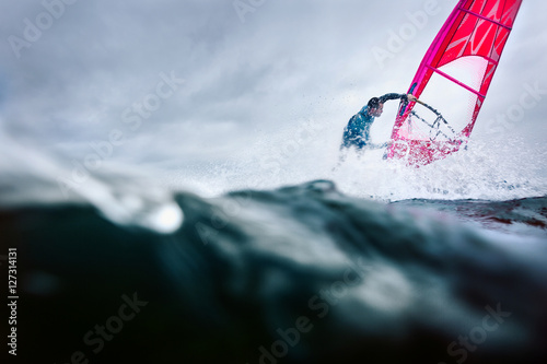 freestyle windsurfer in a huge splash