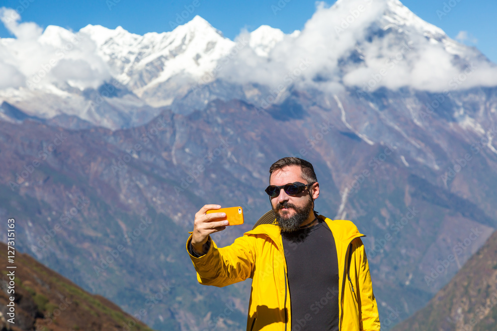 Man taking self portrait with telephone during mountain trekking