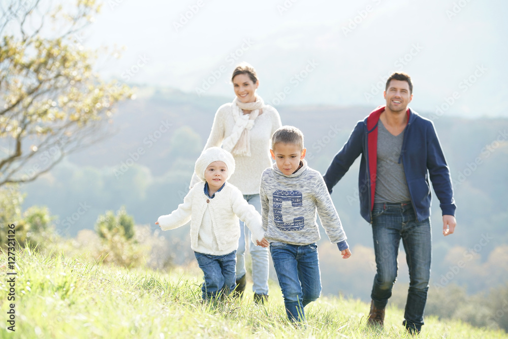 Happy family walking in countryside on autumnal week-end