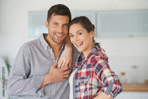 Happy couple standing in brand new home