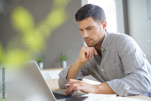 Middle-aged man working from home on laptop computer