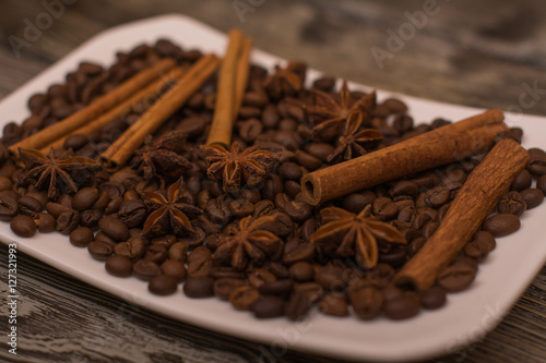 Cocoa beans, cinnamon sticks, star anise on wooden background