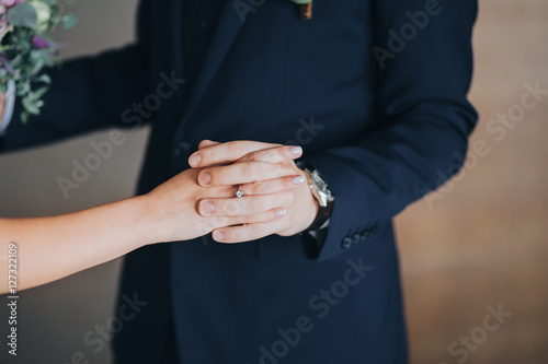 The groom holds his bride's hand. the bride's wedding ring on the finger