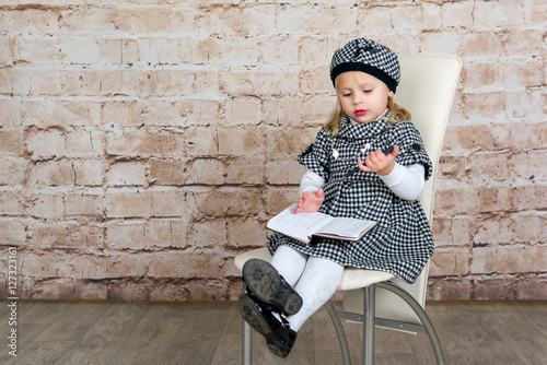 The child, a little girl in a business suit writes in a notebook. The future journalist. Business girl. Education, training and development of preschool children.
