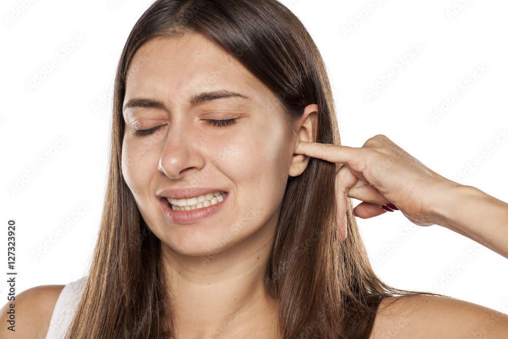 nervous young woman scratching her ear with a finger.. nervous young woman scratching her ear with a finger..