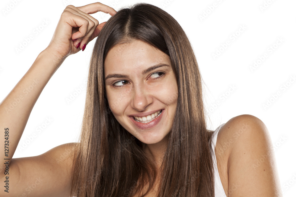 smiling young woman thinking and scratching her head smiling young woman thinking and scratching her head