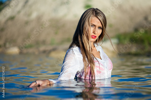 Fototapeta Naklejka Na Ścianę i Meble -  Caucasian model posing in wet white shirt in water.