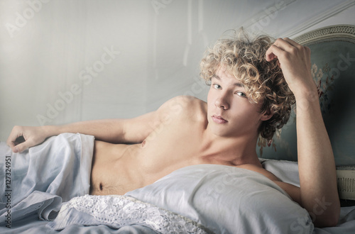 Obraz na płótnie Handsome young man lying in bed