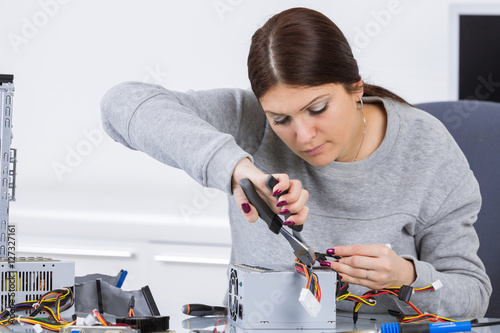 Photos Lady working on computer with pliers