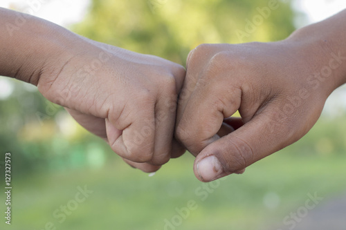 Two men bumping fists © kayasit