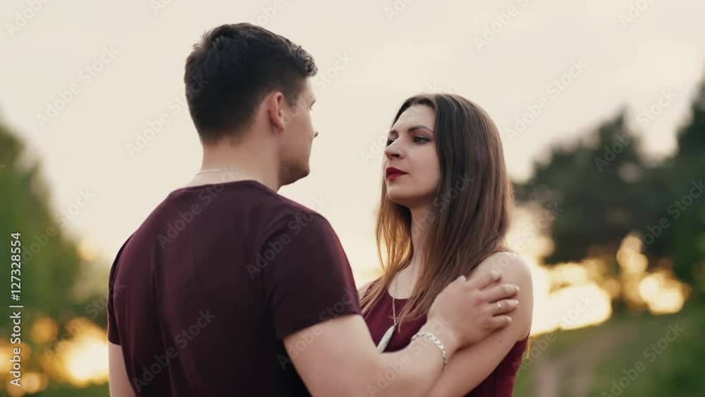 Young beautiful couple have fun. Lovers stand in front of each other, man tousles womans hair, she smiles. Slow mo Young beautiful couple have fun. Lovers stand in front of each other, man tousles womans hair, she smiles. Slow mo