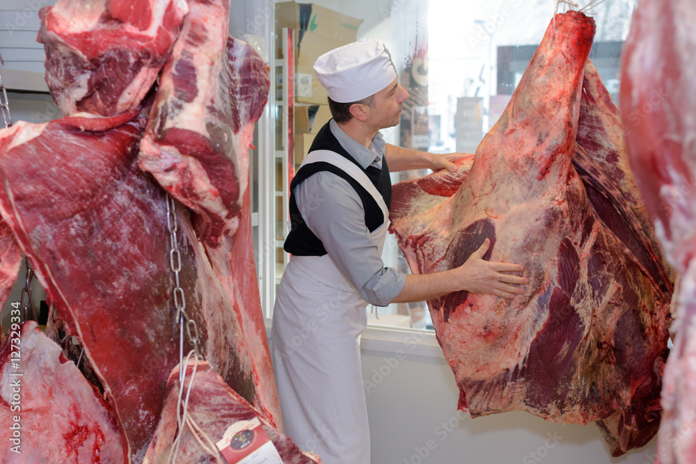 Foto Butcher with animal carcass