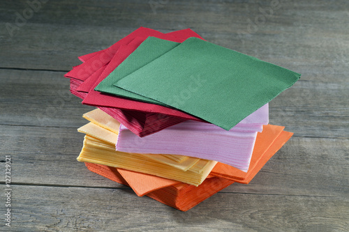 Multicolored paper napkins on wooden table