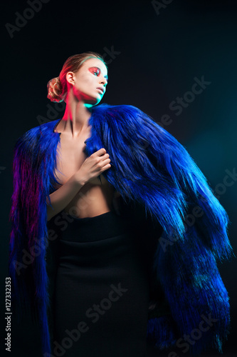 Fashion portrait of beautiful sexy woman model with creative make-up in long blue luxury fur coat