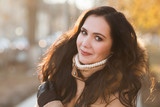 winter outdoor portrait of Girl cute funny positive. Sunny day. Portrait of an attractive brunette in the street.

